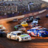 A pack of Street Stock drivers racing their cars around The Dirt Track at Charlotte during the World Short Track Championship