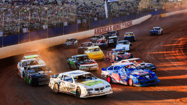 A pack of Street Stock drivers racing their cars around The Dirt Track at Charlotte during the World Short Track Championship